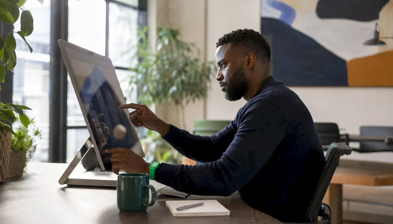 Hands managing digital media on touchscreen desktop