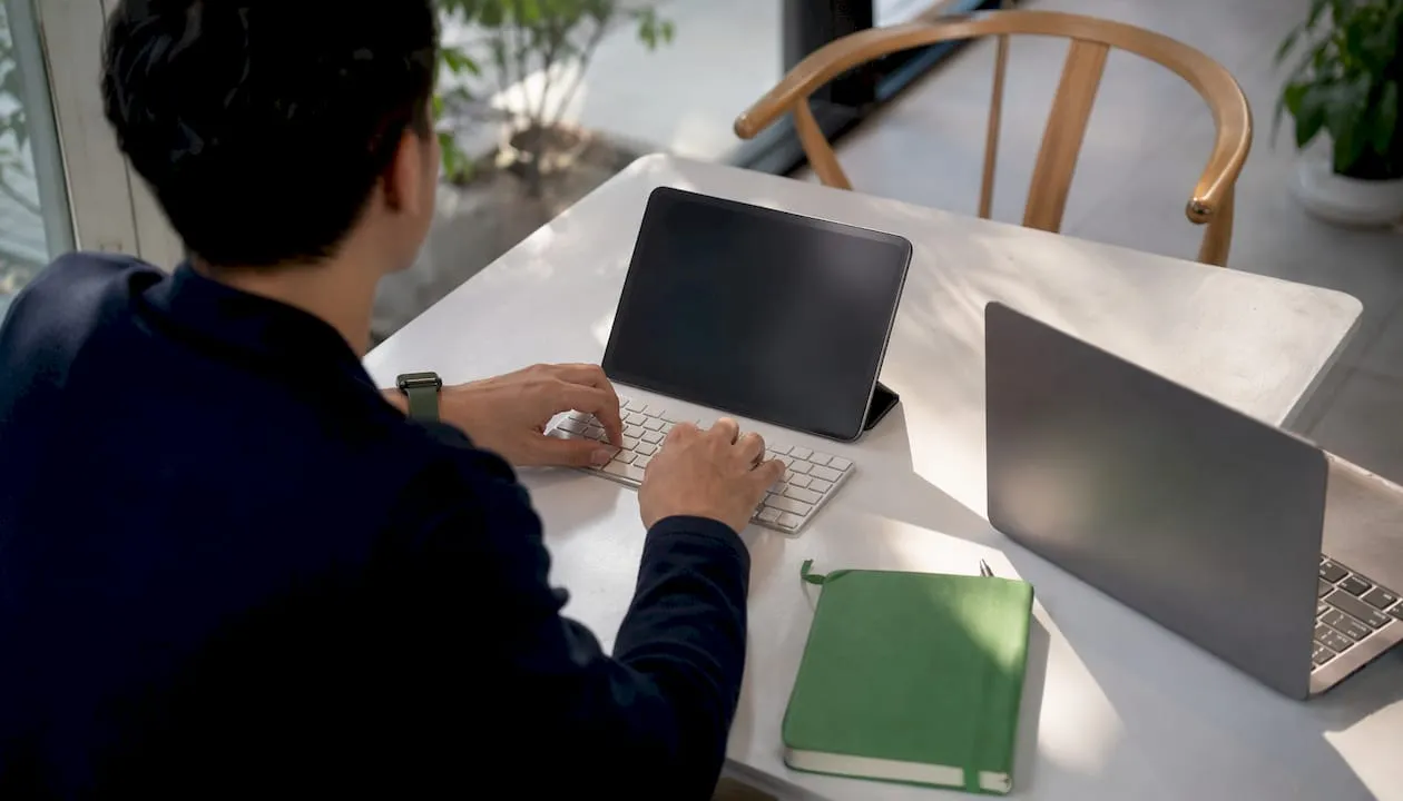 Hands typing SEO content prompts in collaborative workspace