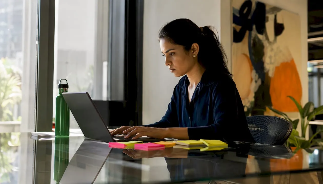 Woman auditing Shopify product listings at desk