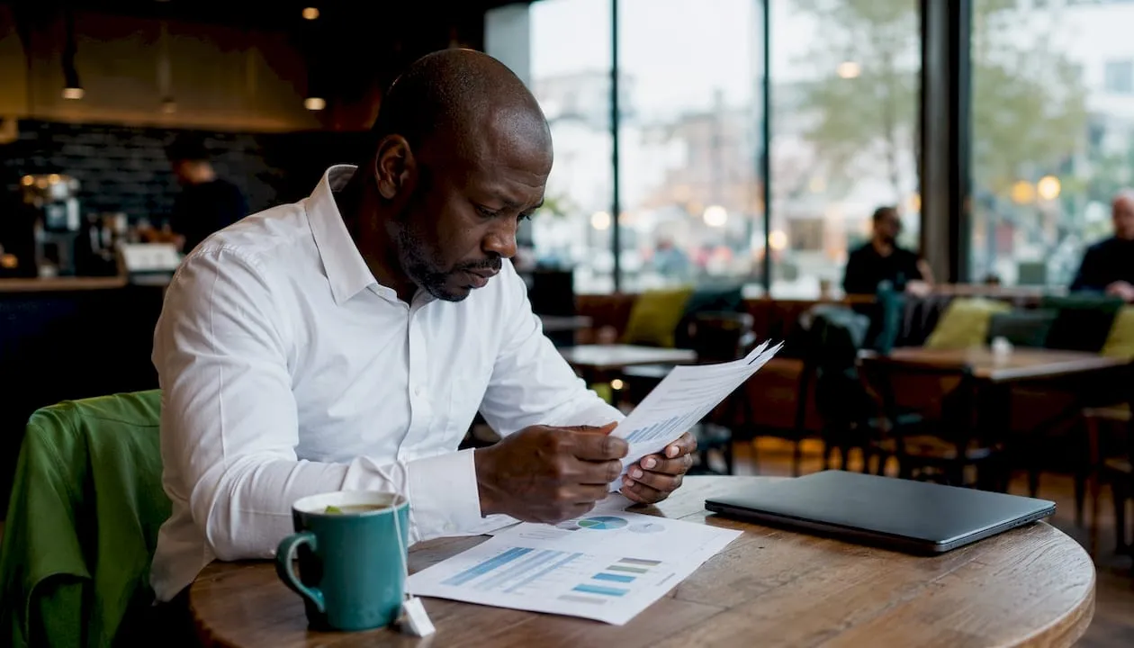 Man reviewing Shopify A/B test printouts in home office