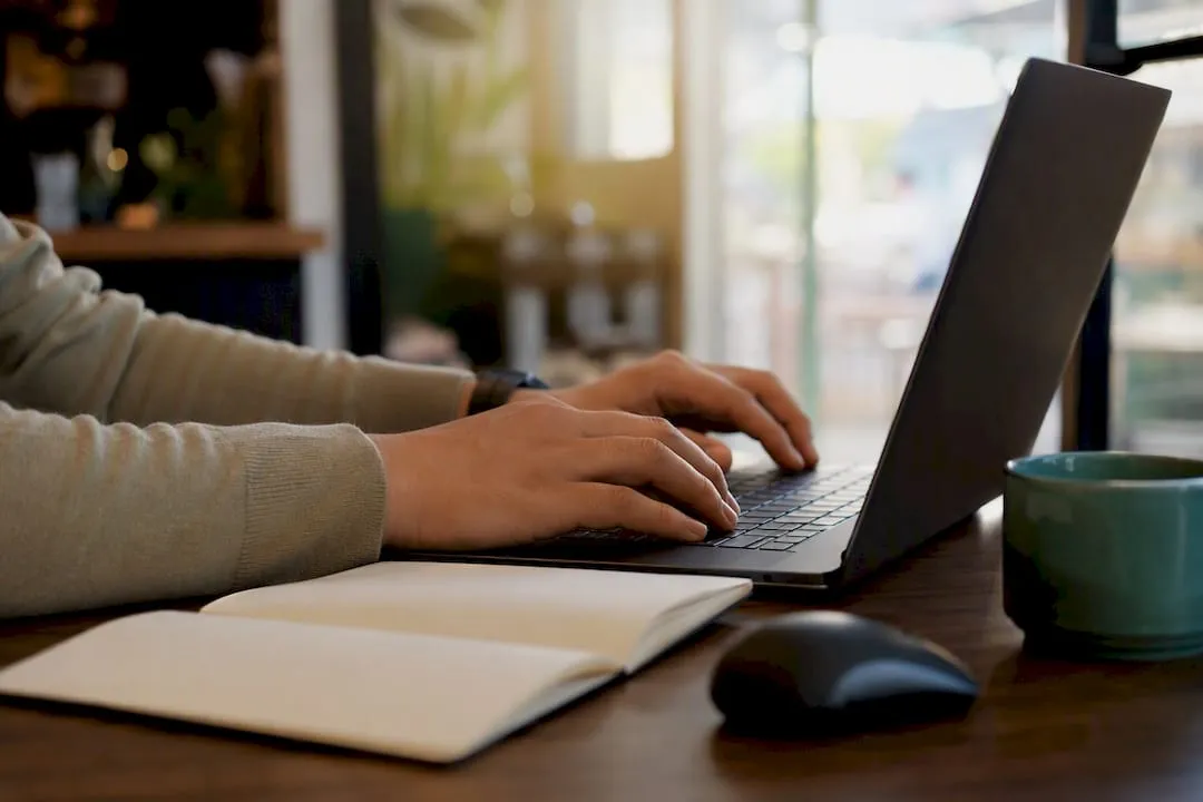 Hands typing AI product description on laptop