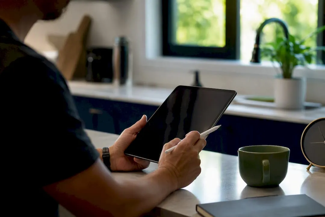 Hands writing notes on tablet tracking ecommerce data