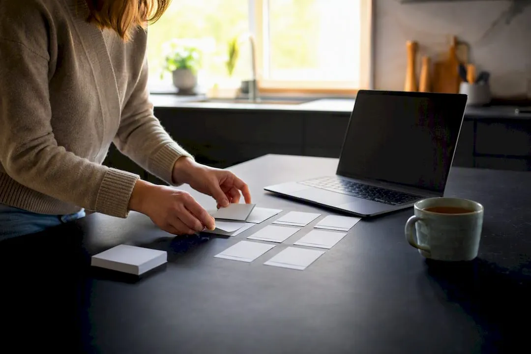 Hands organizing product attribute cards at desk